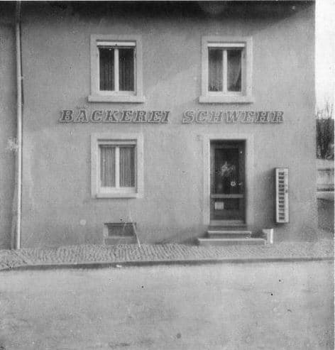 Schlichte Fassade mit Leuchtschriftzug ‚BÄCKEREI SCHWEHR‘