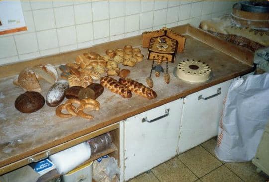 Brot-Stillleben auf der Backstuben-Werkbank mit Hefezopf, Kringel und Stollen